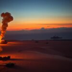 Flick International Aerial view of a desert landscape in Yemen with smoke from military explosions