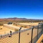 Flick International Wide-angle view of the U.S.-Mexico border showing a rugged landscape with security measures