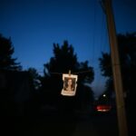 Flick International Dimly lit suburban house with a 'missing person' poster during twilight