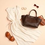 Flick International Stylish flat lay of Michael Kors products featuring a luxury handbag, hoop earrings, sandals, a midi dress, tote bag, and watch