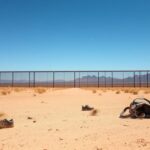 Flick International A desolate landscape of the U.S.-Mexico border in El Paso, Texas, featuring an unfinished border wall