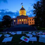 Flick International View of the Vermont State Capitol at dusk with protest signs in the foreground