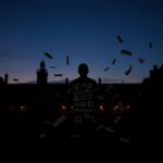 Flick International Silhouette of Georgetown University campus at dusk with shadowy figure representing complexities of law and ideology