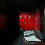 Flick International Dimly lit football locker room showing worn lockers and Stanford memorabilia, depicting tension and conflict