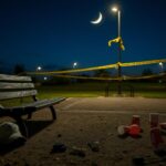 Flick International deserted park in Las Cruces, New Mexico, showing a weathered bench and scattered items after a tragic shooting