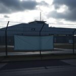 Flick International ICE detention facility in Newark, New Jersey, surrounded by barbed wire and high-security fencing