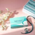 Flick International Flat lay of the Teal Wand at-home cervical cancer screening kit on a pastel background