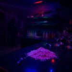 Flick International Dark underground nightclub interior with shadows and neon lighting