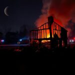 Flick International Aftermath of a house fire in New Jersey illuminated by smoldering debris