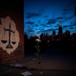 Flick International A mural depicting a gavel and scales of justice in a dimly lit urban environment