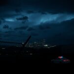 Flick International A nighttime view of Nashville with a chain-link fence and police vehicle symbolizing immigration tension
