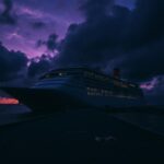 Flick International A large cruise ship silhouetted against a dark stormy sky at twilight