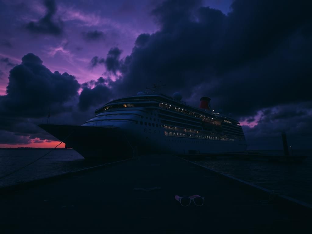 Flick International A large cruise ship silhouetted against a dark stormy sky at twilight