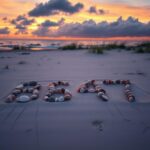 Flick International A desolate beach scene at sunset with seashells forming the numbers '8647'.
