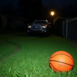 Flick International A suburban front yard at dusk with a parked Toyota Sequoia and an abandoned basketball.