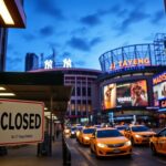 Flick International Desolate NJ Transit station with a CLOSED sign against a backdrop of an illuminated New York City sporting event.