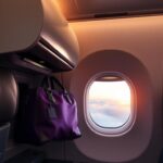 Flick International Cozy airplane cabin with a window seat during sunset