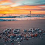 Flick International Artistic arrangement of seashells spelling '86 45' on a serene beach at sunset