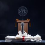 Flick International Graduation stage with empty podium and NYU emblem in the background