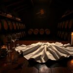 Flick International Elegant winery interior with wooden table and half-filled wine glasses
