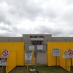 Flick International Exterior view of Delaney Hall immigration detention facility with security barricades