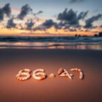 Flick International Serene beach scene at sunset with seashells spelling '86' and '47'