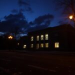Flick International Exterior view of the Capital Jewish Museum illuminated at night with a somber atmosphere