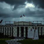 Flick International Dramatic view of the Pentagon building under dark clouds with a chain-link fence
