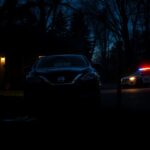 Flick International A dark suburban street scene at twilight, featuring a black Nissan parked ominously