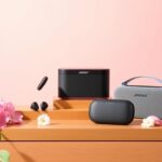 Flick International Collection of Bose audio products including QuietComfort Ultra Earbuds and SoundLink Revolve+ II on a stylish wooden surface