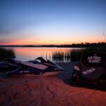 Flick International Sunset over Lake Grapevine with deserted jet skis and open suitcases symbolizing lost potential