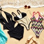 Flick International Stylish swimwear collection displayed on a sandy beach with waves in the background