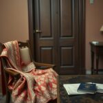 Flick International Ornate Indian wedding outfit draped over a wooden chair, symbolizing family estrangement.