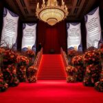 Flick International Lavishly decorated Met Gala venue with vibrant floral arrangements and a luxurious red carpet