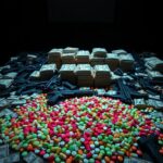 Flick International table covered with assorted seized illegal drugs, featuring colorful fentanyl pills and stacks of cash