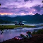 Flick International Serene Honduran landscape at dusk with a UH-60 Black Hawk helicopter partially obscured by leaves, symbolizing the absence of its pilot.