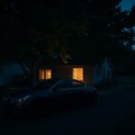 Flick International Dark suburban neighborhood with a black Nissan Altima parked outside a single-family home at twilight