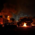 Flick International Chaotic urban scene in Los Angeles during ICE raids with burning cars and graffiti
