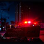 Flick International Night scene in Los Angeles with police vehicles and a broken street sign
