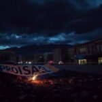 Flick International Dark cityscape of Boulder, Colorado, depicting fragments of a pro-Israel banner and debris hinting at chaos after the recent terror attack