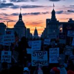 Flick International A vibrant protest scene at dusk with colorful signs against a darkening skyline