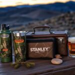 Flick International A dynamic collection of Stanley products featuring camo designs on a rustic wooden table
