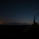 Flick International Dramatic night sky over a tense Middle Eastern landscape with communication devices scattered on the ground