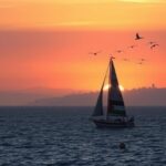 Flick International A Palestinian-flagged sailing vessel at dusk, symbolizing hope and uncertainty on its way to Gaza.