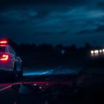 Flick International Dark highway scene showing a police cruiser with flashing lights at the site of a fatal DUI crash