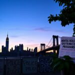 Flick International Dynamic urban scene of New York City skyline at dusk with police barricades and protest signs