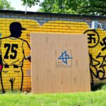 Flick International Mural depicting baseball legends Jackie Robinson and Minnie Miñoso with graffiti vandalism visible