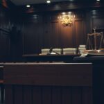 Flick International Dimly lit courtroom scene with an empty wooden witness stand and ornate judge's bench