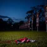 Flick International Dark and atmospheric view of a deserted public park in Bogotá, Colombia, during twilight, with a bloodstained piece of clothing on the ground