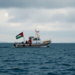 Flick International Humanitarian aid boat 'Madleen' with Palestinian flag on a deep blue sea under an overcast sky